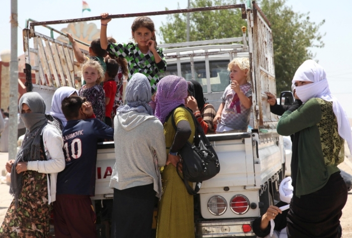 Displaced families from the minority Yazidi sect, fleeing the violence in the Iraqi town of Sinjarl west of Mosul, arrive at Dohuk province, August 4, 2014.
