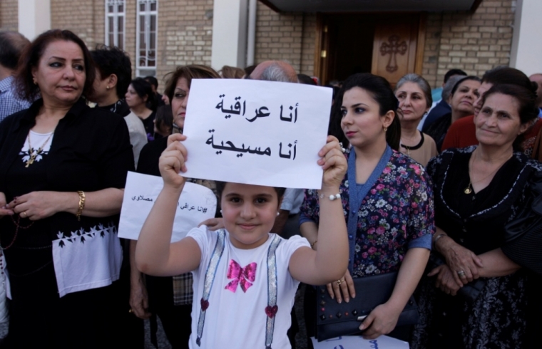 A girl holds up a sign that reads: 'I am an Iraqi, I am a Christian' at Mar Girgis Church in Baghdad, July 20, 2014. The head of Iraq's largest church said on Sunday that Islamic State militants who drove Christians out of Mosul were worse than Mongol leader Genghis Khan and his grandson Hulagu who ransacked medieval Baghdad. Chaldean Catholic Patriarch Louis Raphael Sako led a wave of condemnation for the Sunni Islamists who demanded Christians either convert, submit to their radical rule and pay a religious levy or face death by the sword. Sako was speaking at the special church service in east Baghdad where around 200 Muslims joined Christians in solidarity.