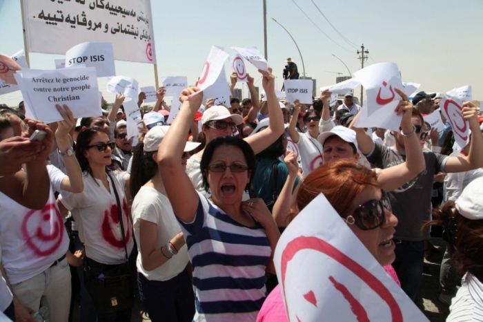 Christian demonstrators carry signs as they protest against militants of the Islamic State, formerly known as the Islamic State in Iraq and the Levant, in Arbil, north of Baghdad July 24, 2014. Hundreds of Iraqi Christians marched to the United Nations office in Arbil city on Thursday calling for help for families who fled in the face of threats by Islamic State militants.