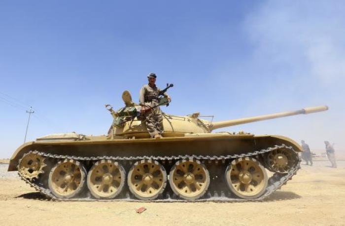 A member of the Kurdish peshmerga troops stands on a tank during an operation against Islamic State militants in Makhmur, on the outskirts of the province of Nineveh August 7, 2014.