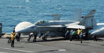 Sailors guide an F/A-18C Hornet assigned to the Valions of Strike Fighter Squadron (VFA) 15 on the flight deck of the aircraft carrier USS George H.W. Bush (CVN 77) in the Gulf, in this handout image taken and released on August 8, 2014.