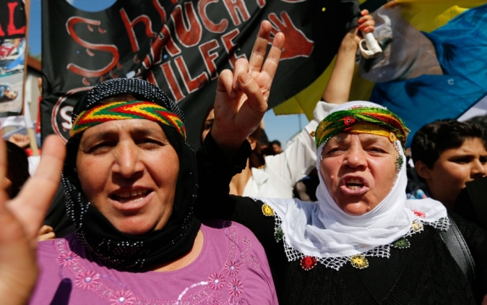 Two Kurdish women of the ethnic minority of Yazidis flash victory signs as they march through the streets of Bielefeld August 9, 2014. Some 10,000 ethnic Kurds of the Yazidis sect, who practice an ancient faith related to Zoroastrianism, protested in the western German city on Saturday against Islamic State (IS) militants. The IS are surging across northern Iraq near the Kurdistan borders in their drive to eradicate unbelievers such as Christians and Yazidis.
