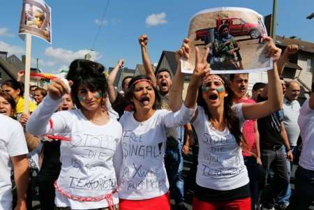 Young Kurdish women of the ethnic minority of Yazidis wear shirts reading "Stop the IS terrorists" and "Free Shingal" as they march through the streets of Bielefeld August 9, 2014. Some 10,000 ethnic Kurds of the Yazidis sect, who practice an ancient faith related to Zoroastrianism, protested in the western German city on Saturday against Islamic State (IS) militants, who are surging across northern Iraq near the Kurdistan borders in their drive to eradicate unbelievers such as Christians and Yazidis.