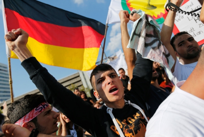 Kurds of the ethnic minority of Yazidis shout slogans against Islamic State (IS) militants during a demonstration in Bielefeld August 9, 2014. Some 10,000 ethnic Kurds of the Yazidis sect, who practice an ancient faith related to Zoroastrianism, protested in the western German city on Saturday against IS militants, who are surging across northern Iraq near the Kurdistan borders in their drive to eradicate non-believers such as Christians and Yazidis.