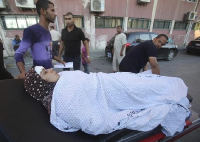A Palestinian woman, whom medics said was wounded in an Israeli air strike, is wheeled on a stretcher at a hospital in Khan Younis in the southern Gaza Strip August 8, 2014.