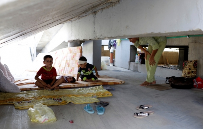 Iraqi Christian children, who fled the violence in the village of Qaraqosh, sit on a mattress at their makeshift shelter in an abandoned building in Arbil, north of Baghdad, August 11, 2014. The children sought sanctuary at the building after fleeing their village to escape the advance of Islamic State militants.