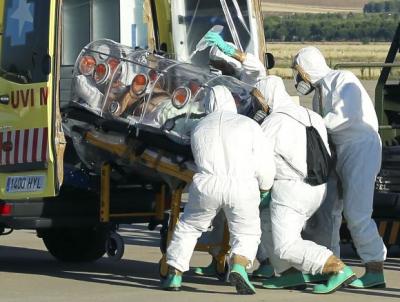 Health workers load Ebola patient, Spanish priest Miguel Pajares, into an ambulance on the tarmac of Torrejon airbase in Madrid, after he was repatriated from Liberia for treatment in Spain, August 7, 2014.