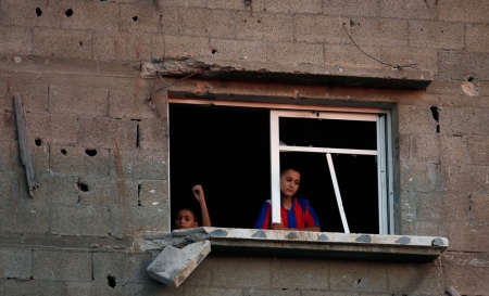 Palestinians look out the window of their damaged house during a 72-hour truce in Beit Hanoun town in the northern Gaza Strip August 12, 2014. Talks to end a month-long war between Israel and Gaza militants are "difficult", Palestinian delegates said on Tuesday, while Israeli officials said no progress had been made so far and fighting could soon resume.