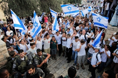 Youths wave Israeli flags near border policemen during a parade marking Jerusalem Day, at Damascus Gate in Jerusalem's Old City May 28, 2014. Nine Palestinians were detained on suspicion of throwing stones at policemen and participants of the parade, an Israeli police spokesman said on Wednesday. Jerusalem Day marks the anniversary of Israel's capture of the Eastern part of the city during the 1967 Middle East War. In 1980, Israel's parliament passed a law declaring united Jerusalem as the national capital, a move never recognised internationally.