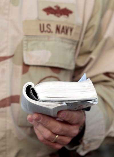 A member of the U.S. Navy reads from a small Bible during an Easter service in Kandahar April 4, 2010.