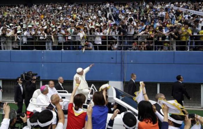 Pope Francis (C) greets faithful as he arrives for the Holy Mass at Daejeon World Cup stadium August 15, 2014.