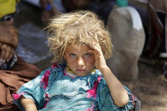 A girl from the minority Yazidi sect, fleeing the violence in the Iraqi town of Sinjar, rests at the Iraqi-Syrian border crossing in Fishkhabour, Dohuk province, Iraq, August 13, 2014. REUTERS/Youssef Boudlal