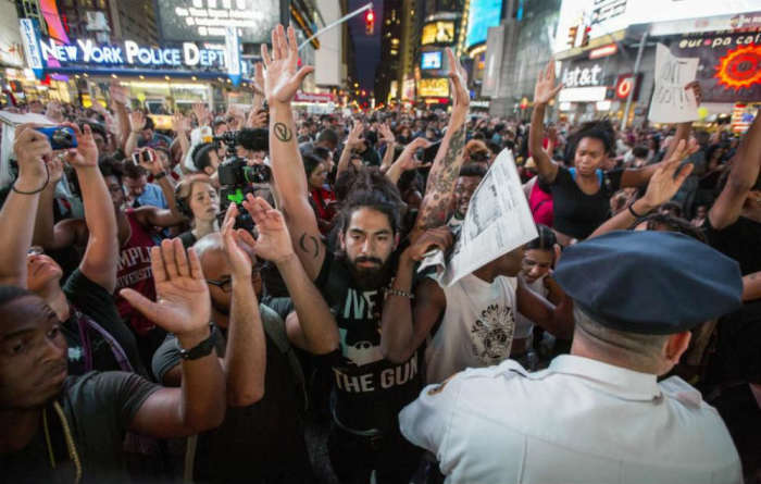 People in New York City gather at Times Square to protest the killing of 18-year-old Michael Brown by Ferguson police officer Darren Wilson.