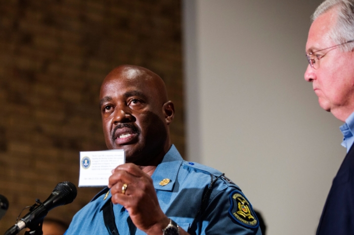 Captain Ron Johnson of the Missouri Highway Patrol holds up an FBI card that is being given to residents as part of an investigation into the shooting of Michael Brown in Ferguson, Missouri August 16, 2014. Missouri Governor Jay Nixon declared a state of emergency and imposed a curfew in Ferguson on Saturday following a week-long series of racially charged protests and looting over the shooting of an unarmed black teenager by a white police officer.