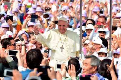Faithful greet Pope Francis (C) as he arrives Gwanghwamun Square in Seoul, South Korea, Aug. 16, 2014. Francis urged South Koreans, among Asia's richest people, to beware of the spiritual 'cancer' that often accompanies affluent societies, as he led a Mass on Friday to commemorate the more than 300 people killed in a ferry disaster in April.
