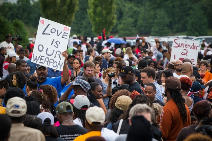 Demonstrators stand in an overflow crowd outside of a church where civil rights leader Al Sharpton spoke with community leaders, as communities continue to react to the shooting of Michael Brown, in Ferguson, Missouri August 17, 2014. U.S. Attorney General Eric Holder ordered a federal autopsy of Brown, a teenager shot dead by a police officer in Ferguson, Missouri, seeking to assure the family and community there will be a thorough investigation into a death that has sparked days of racially charged protests.
