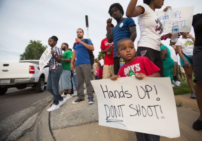 Romel Turner, 3, holds a sign during a peaceful demonstration at Great St. Mark Family Church, as communities react to the shooting of Michael Brown in St. Louis, Missouri August 14, 2014. Missouri's governor Jay Nixon moved on Thursday to calm days of racially charged protests over the police shooting of Brown, an unarmed black teenager, naming the African-American captain of the Highway Patrol Ron Johnson to oversee security in the St. Louis suburb of Ferguson.