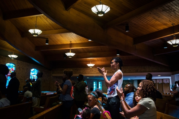 Parishioners applaud after listening to civil rights leader Al Sharpton after he spoke during church services at the Greater St Mark Family Church as the community discusses reactions to the shooting of teenager Michael Brown in Ferguson, Missouri August 17, 2014. The Ferguson police department has come under strong criticism for both the shooting and its handling of its aftermath. On Sunday U.S. Attorney General Eric Holder ordered a federal medical examiner to perform an autopsy, in addition to one being conducted by state medical examiners.