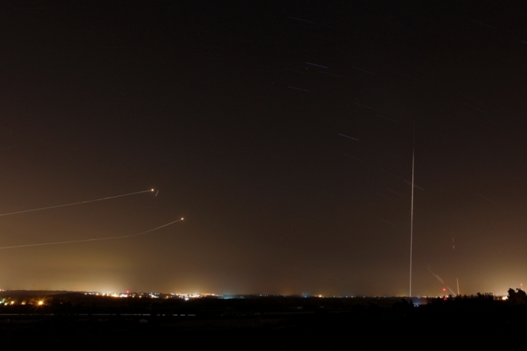 Rockets launched from the Gaza Strip toward Israel is seen (at right) as a rocket by the Iron Dome anti-missile system (at left) is fired to intercept them, before a five-day ceasefire was due to expire, Aug. 19, 2014. A ceasefire in the Gaza Strip collapsed on Tuesday, with Palestinian militants firing rockets into Israel, prompting Israeli air strikes that health officials said killed a woman and a young girl.