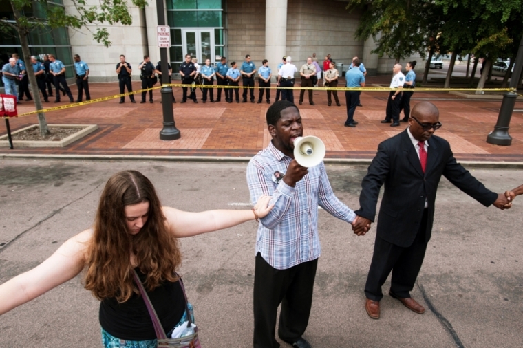Protestors pray for justice outside the St. Louis County Justice Building in Clayton, Missouri, on Aug. 20, 2014. Prosecuting attorney Bob McCulloch may present initial evidence to the grand jury today in the police shooting of Michael Brown in Ferguson, Aug. 9.