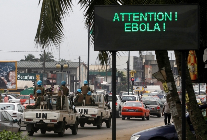 A U.N. convoy of soldiers passes a screen displaying a message on Ebola on a street in Abidjan, Ivory, Coast, Aug. 14, 2014. The world's worst outbreak of Ebola has claimed the lives of 1,069 people and there are 1,975 probable and suspected cases, the vast majority in Guinea, Liberia and Sierra Leone, according to new figures from the World Health Organization. Ivory Coast has recorded no cases of Ebola.