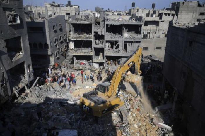 Palestinians gather as rescue workers search for victims under the rubble of a house, which witnesses said was destroyed in an Israeli air strike that killed three senior Hamas military commanders, in Rafah in the southern Gaza Strip August 21, 2014.
