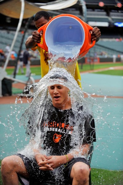 Baltimore Orioles outfielder pours a bucket of ice water on third baseman Manny Machado as part of the ALS ice bucket challenge prior to a game against the New York Yankees at Oriole Park at Camden Yards, Baltimore, Maryland, Aug. 11, 2014.