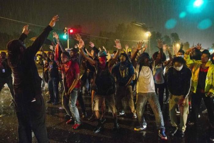 Protesters in a street showed defiance of a midnight curfew meant to stem ongoing demonstrations in reaction to the shooting of Michael Brown in Ferguson, Missouri (August 2014)