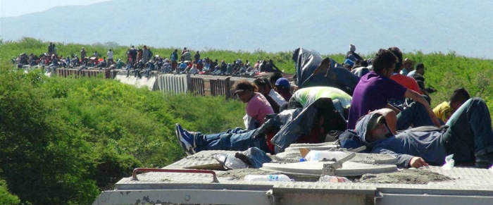 Unaccompanied minors ride atop the wagon of a freight train, known as La Bestia (The Beast) in Ixtepec, in the Mexican state of Oaxaca on June 18, 2014.