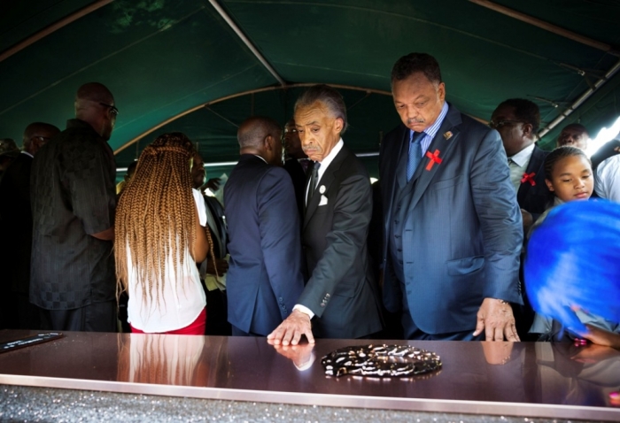 Rev. Al Sharpton and Jessie Jackson (R) touch the casket of Michael Brown at St. Pete's Cemetery in St. Louis, Missouri, Aug. 25, 2014.