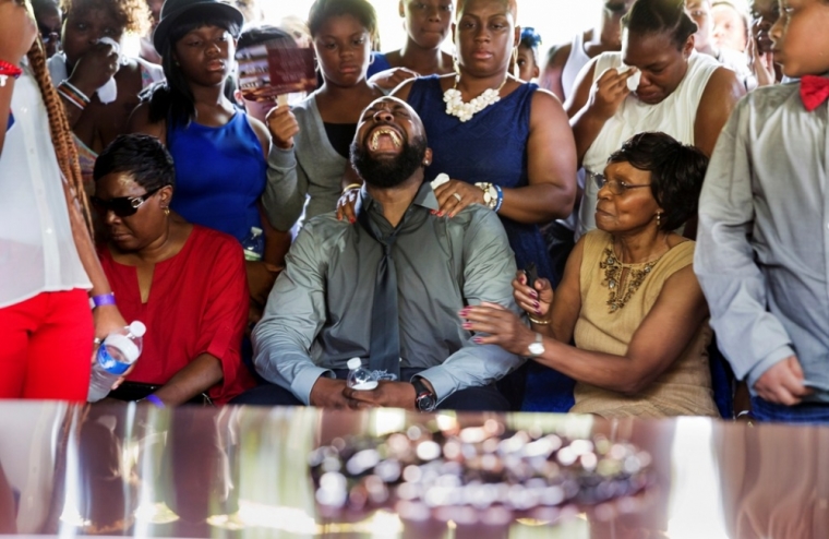 Michael Brown Sr. yells out as his son's casket is lowered into the ground at St. Pete's Cemetery in St. Louis, Missouri, Aug. 25, 2014. Family, politicians and activists gathered for the funeral on Monday following weeks of unrest with at times violent protests spawning headlines around the world focusing attention on racial issues in the United States.