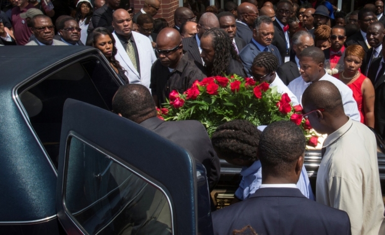 Lesley McSpadden (R, in red) watches as the casket containing the body of her son Michael Brown lifted into a hearse after his funeral services at Friendly Temple Missionary Baptist Church, St. Louis, Missouri, Aug. 25, 2014.