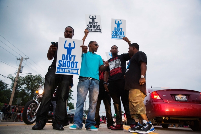 Demonstrators gesture and chant as they continue to react to the shooting of Michael Brown in Ferguson, Missouri August 17, 2014. U.S. Attorney General Eric Holder ordered a federal autopsy of Brown, a teenager shot dead by a police officer in Ferguson, Missouri, seeking to assure the family and community there will be a thorough investigation into a death that has sparked days of racially charged protests.