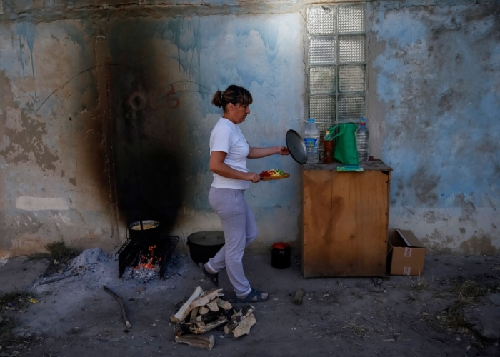 A woman prepares food in the Ukrainian city of Avdeevka near Donetsk, August 27, 2014. Fighting between the Ukrainian army and pro-Russian separatists have rendered the city without electricity and gas.