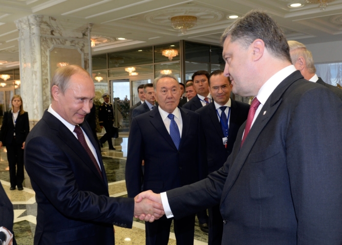 Russian President Vladimir Putin (L) shakes hands with his Ukrainian counterpart Petro Poroshenko, as Kazakh President Nursultan Nazarbayev (C) stands nearby, in Minsk August 26, 2014. Putin and Poroshenko greeted each other with a handshake at the start of talks in Belarus on Tuesday on the Ukraine crisis, the first time the two presidents have met since June