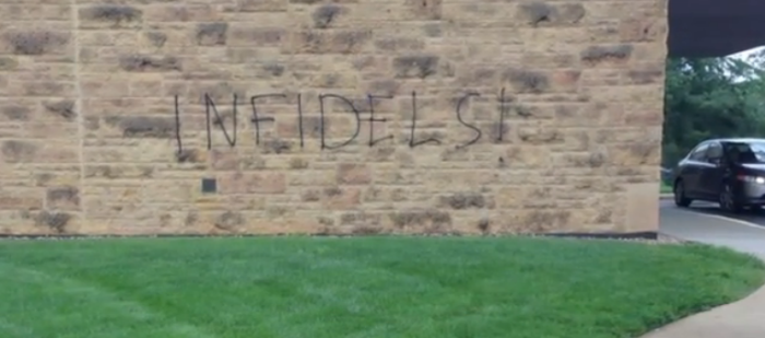 A Columbus, Indiana church that was vandalized by graffiti. It reads 'infidels'
