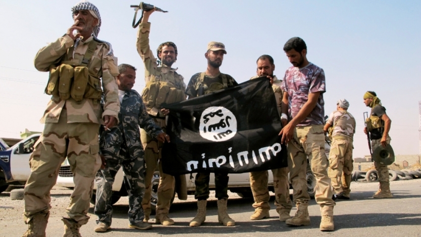 Iraqi security forces and Shi'ite militias pull down a flag belonging to Islamic State militants at Amerli, Sept. 1, 2014. U.S. President Barack Obama on Monday formally notified Congress that he had authorized targeted air strikes in Iraq to help deliver a humanitarian aid to the besieged Shi'ite town of Amerli, the White House said in a statement. Iraqi security forces backed by Shi'ite militias on Sunday broke the two-month siege of Amerli by Islamic State militants and entered the northern town, after U.S. military carried out air strikes on IS militant positions near the town and airdropped humanitarian supplies to the trapped residents there.