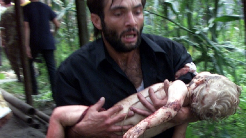 A volunteer carries a small child after special forces stormed a school seized by heavily armed masked men and women in the town of Beslan in the province of North Ossetia near Chechnya , September 3, 2004.