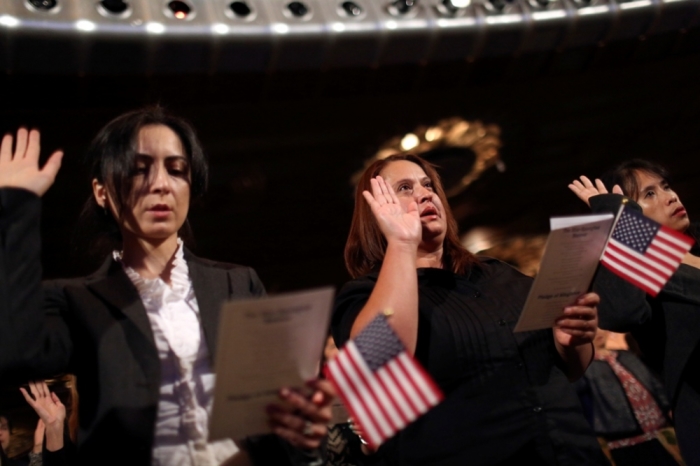 Immigrants recite the Pledge of Allegiance during an oath of citizenship during a U.S. Citizenship and Immigration Services ceremony in Oakland, California, on Aug. 13, 2014. About 1,000 immigrants from 97 countries attended the ceremony.
