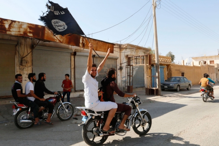 A resident of Tabqa city touring the streets on a motorcycle waves an Islamist flag in celebration after Islamic State militants took over Tabqa air base, in nearby Raqqa city August 24, 2014. Islamic State militants stormed the air base in northeast Syria on Sunday, capturing most of it from government forces after days of fighting over the strategic location, a witness and a monitoring group said. Fighting raged inside the walls of the Tabqa air base, the Syrian army's last foothold in an area otherwise controlled by IS, which has seized large areas of Syria and Iraq.