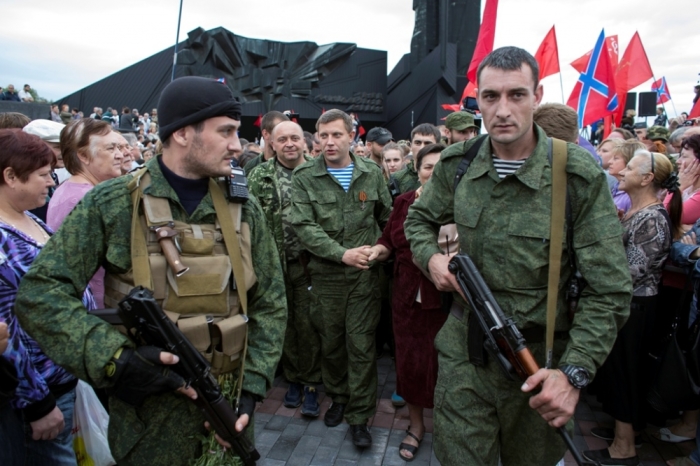 Prime Minister of the rebels' self-proclaimed 'Donetsk People's Republic,' Alexander Zakharchenko (C) walks surrounded by people during a ceremony to honor the World War II defenders of Donetsk from Nazi forces in Donetsk, Sept. 8, 2014. A ceasefire struck between Ukrainian forces and pro-Russian separatists was largely holding on Monday in eastern Ukraine despite sporadic violations, but Europe's security watchdog said the sides must push for a political settlement.