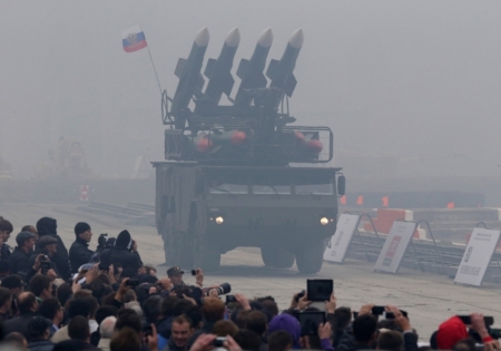 Spectators watch a Russian "Buk" missile system being driven during the "Russia Arms Expo 2013" Ninth international exhibition of arms, military equipment and ammunition, in the Urals city of Nizhny Tagil, Sept. 25, 2013.