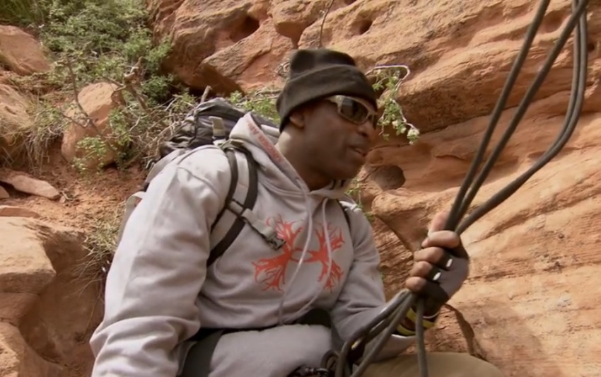 NFL Hall of Famer Deion Sanders stops for a break while ascending a Utah mountain during an episode of "Running Wild with Bear Grylls."