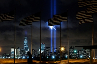 A man walks past as the Tribute in Light is illuminated on the skyline of lower Manhattan during events marking the 13th anniversary of the 9/11 attacks on the World Trade Center in New York, Sept. 10, 2014. 