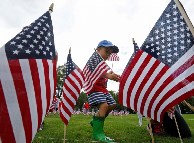 Charlie Lewis, 3, plants some of the 3,000 flags placed in memory of the lives lost in the Sept. 11, 2001, attacks at a park in Winnetka, Illinois, Sept. 10, 2014.