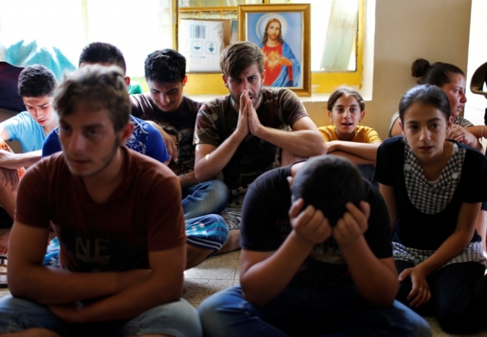 Displaced Iraqi Christians who fled from Islamic State militants in Mosul, pray at a school acting as a refugee camp in Erbil, Sept. 6, 2014.
