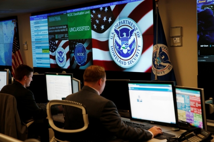 U.S. Department of Homeland Security employees work in front of U.S. threat level displays inside the National Cybersecurity and Communications Integration Center during a guided media tour in Arlington, Virginia, June 26, 2014.