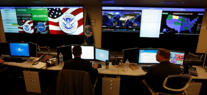 U.S. Department of Homeland Security employees work in front of U.S. threat level displays inside the National Cybersecurity and Communications Integration Center as part of a guided media tour in Arlington, Virginia, June 26, 2014.