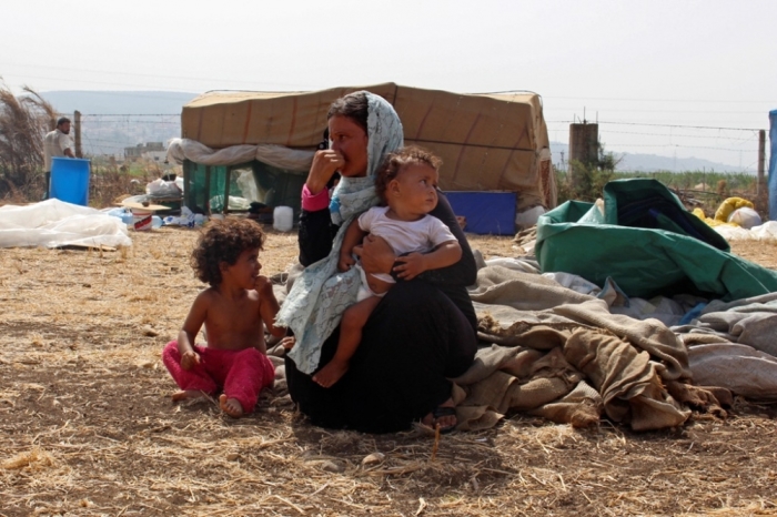 Syrian refugees rest with their belongings in Halba, Akkar, September 24, 2014. Syrian refugees, fleeing from violence back home to Halba in Lebanon, said they were stopped by local authorities from building temporary shelters in an area which they said they had rented, and were asked to leave the vicinity within a week.