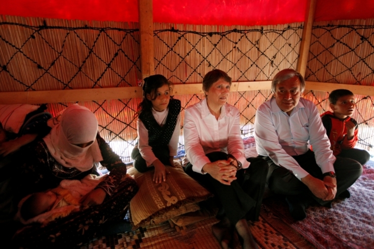 A Syrian refugee family from Raqqa rest in their tent beside Administrator of the United Nations Development Programme Helen Clark (C), and High Commissioner of UN refugee agency Antonio Guterres(2nd R) in Deir al-Ahmar, Bekaa valley, September 16, 2014. Senior UN officials visited Syrian refugees, who now make up one-fourth of Lebanon's entire population, in the Bekaa region on Tuesday and called for the international community to assist the Lebanese government in dealing with the refugee crisis.